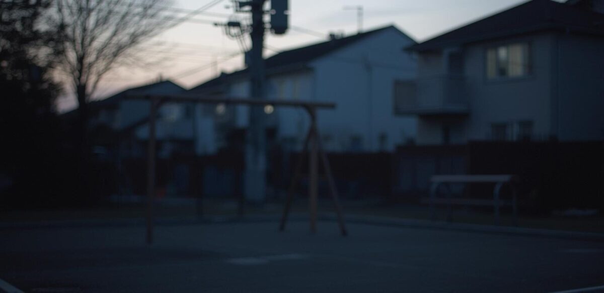 夕方の公園にブランコとベンチが見える
